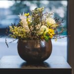 Tischdeko Vase in Schlagmetall silber mit Trockenblumen, Limonium, Farn und Seidenblumen in gelb und weiß