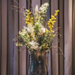 Raumgestaltung Vase in Rauchgrau mit Trockenblumen, Limonium, Farn und Seidenblumen in gelb und weiß