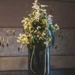 Raumgestaltung Vase in Rauchgrau mit Trockenblumen, Limonium, Farn und Seidenblumen in gelb und weiß